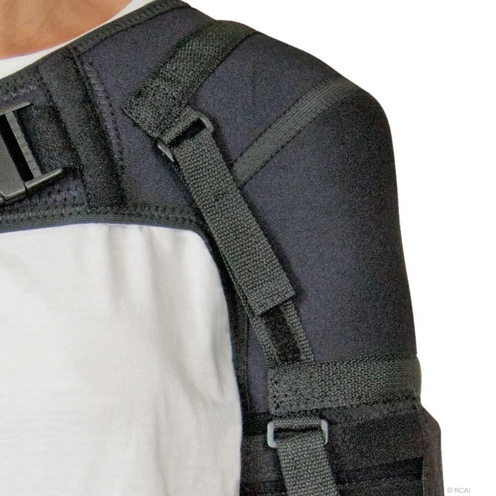 Black neoprene shoulder stabilizer with adjustable straps on a white shirt, made in the USA, RCAI, B2B orthopedics.